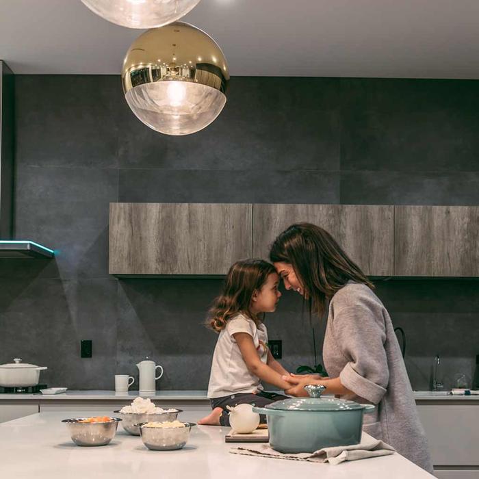 A parent and child cooking together in a bright kitchen