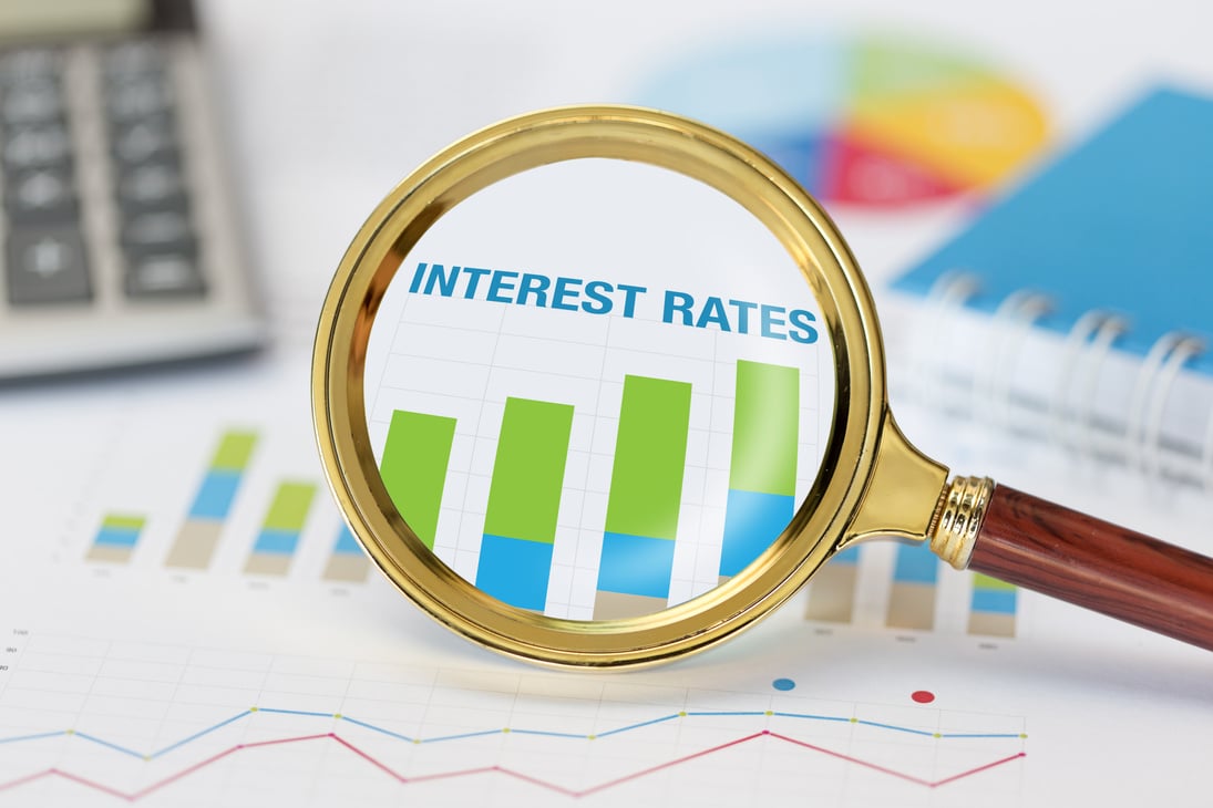 Magnifying glass and calculator on interest rates graph